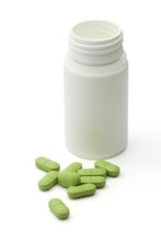Green vitamin pills with dose on white background